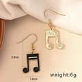 Detailansicht der Musiknoten-Ohrringe mit 3,9 cm Höhe und goldener gebürsteter Textur - Achtelnoten-Form / E91-Musik (Asymmetrische Note)