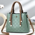 Detail of mint green checkered texture handbag with brown straps and gold hardware - Green