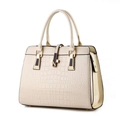 Dettaglio della texture a coccodrillo su borsa beige con fibbia a V dorata - Bianco