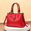 Detail of red PU leather handbag with black petal clasp and round metallic rings - Red