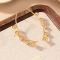 Elegant gold-plated hoop earrings with small spherical accents on a textured backdrop - Gold