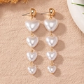 Elegant gold drop earrings featuring four white heart-shaped pearls in a tiered tassel design - White