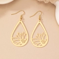 Dettaglio ravvicinato di orecchini a forma di goccia dorata con intaglio di girasole - Oro