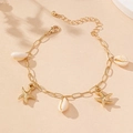Flat lay of gold starfish and seashell bracelet on a warm sandy beach background - Gold Starfish (5505944745553)