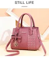 Détail du sac à main rose poudré avec texture tissée et breloque coeur sur support épuré - Rose