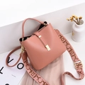 Dusty pink bucket bag in lychee texture with jacquard strap and gold hardware accents - Pink