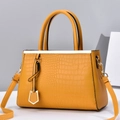 Chic ginger yellow tote bag with crocodile texture and gold hardware on minimalist background - Yellow