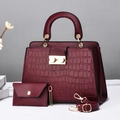Vista macro della borsa bordeaux con motivo a coccodrillo, fibbia d'oro e pochette - Borgogna