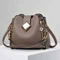 Detail of lychee pattern leather bucket bag with gold hardware and white stitching - Khaki