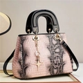 Detail of pink and gray snake texture handbag with golden star pendant and black patent leather - Pink