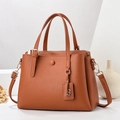 Detail of brown litchi pattern leather tote bag with gold hardware and B-pendant - Yellow