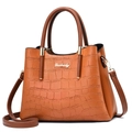 Detailed view of crocodile embossed leather texture and gold logo on brown tote bag - Crocodile Pattern Earthy Yellow