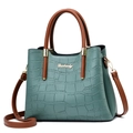 Detail of crocodile pattern leather bag with golden Danbaoly logo and brown handle - Green Crocodile Pattern
