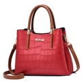 Detail of red crocodile texture handbag with golden Danbaoly logo and brown handle - Wine Red Crocodile Pattern