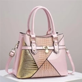 Detail of pink faux leather handbag showing glossy lizard texture and golden hardware - Pink