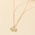 Bohemian gold elephant pendant necklace with intricate mandala patterns on a textured surface - Gold