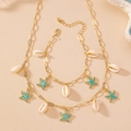 Goldenes Seestern- und Muschel-Halsketten- und Armbandset auf Sandstrand-Hintergrund - Hellblau 2-Teiliges Set