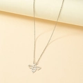 Détail du pendentif abeille géométrique argentée sur une fine chaîne maille forçat - Or Blanc