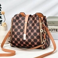 Retro bucket bag with contrast monogram print and gold hardware in a lifestyle setting - M Earthy Yellow
