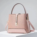 Borsa a secchiello in pizzo rosa con finiture dorate e tracolla su espositore bianco - Rosa