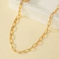 Collana a catena a graffetta dorata minimalista su un supporto geometrico moderno - Oro