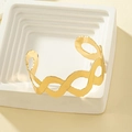 Goldener verstellbarer Armreif mit abstrakter Wellentextur auf minimalistischem Display - Gold