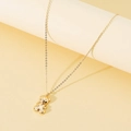 Minimalist gold necklace with a polished 3D teddy bear pendant on a display stand - Gold