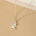 Minimalist silver teddy bear pendant necklace on a premium textured aesthetic background - Silver