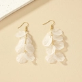 Details von eleganten weißen Harzblüten-Ohrringen mit goldenen Ketten und Fischhaken - Transparentes Muschelweiß