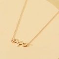 Golden heart and pet paw pendant necklace on a minimalist display stand - Gold