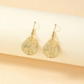 Golden teardrop earrings with irregular hammered texture and classic hook design - Gold