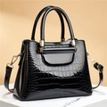 Detail of black glossy crocodile pattern tote with gold metal lock and leather strap - Stone Pattern Black