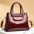 Close-up of wine red crocodile embossed patent leather tote bag with gold hardware - Stone Pattern Red