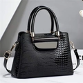Bolso de mano negro brillante con diseño de cocodrilo, herrajes dorados y asa superior - Negro