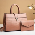 Detail view of pink crocodile-embossed tote bag and matching clutch set with golden hardware - Pink