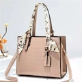 Detail der rosa Handtasche mit Krokodilprägung, dekorativem Seidenschal und Metallbeschlägen - Khaki