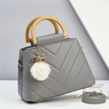 Detail of grey quilted tote bag with wooden handle, plush pom-pom and adjustable strap - Gray