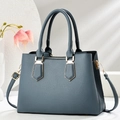 Elegant misty blue pebbled leather tote bag with gold hardware and top handles - Blue