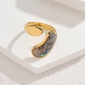 Makroaufnahme eines vergoldeten Rings mit schillernder Abalone-Muschel auf weißem Stein - Organisch Gebogener Bunter Abalone-Stil (CXR916-A-cai)
