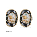 Detailed view of vintage oval earrings with gold rose relief and black enamel frame - Earrings