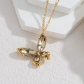 Detail van de gouden vlinderketting hanger met kristallen op een witte stenen standaard - Grijze Vlinder Ketting (F-S143-N-hui)