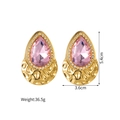 Detail van roze druppeloorbellen met gouden textuur basis en witte kristallen - Roze