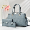 Detailed view of light blue three-piece bag set featuring crocodile texture and gold zippers - Blue