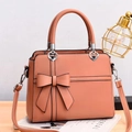 Coral orange bow textured crossbody bag with heart hardware and adjustable strap - Brick Red