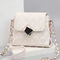 White quilted crossbody bag with gold chain strap and diamond-shaped clasp on a white stand - Small / White