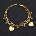 Elegante pulsera de cadena dorada de doble capa con colgantes de corazón en fondo negro - Dorado