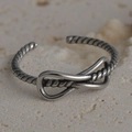 Macro shot of vintage knotted silver ring featuring a detailed twisted rope texture - Knot & Twisted Braided Style (R563)