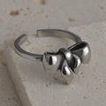 Macro shot of vintage silver bow ring on travertine stone showing antique texture - Retro Matte Bow Knot Style (R559)