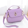 Sac bandoulière violet en similicuir avec rabat matelassé et fermoir doré sur table - Violet