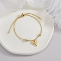 Elegant gold heart pendant bracelet with adjustable slider clasp on a white decorative tray - Bead Heart Bracelet
